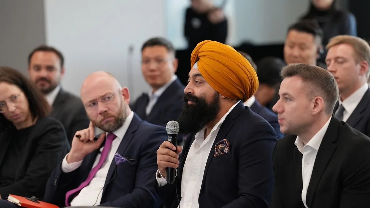 Arvinder Singh Kang holding a microphone during a discussion at Tsinghua University